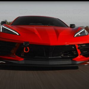 Front view of a red Corvette C8 Legacy Edition in motion on a racetrack.