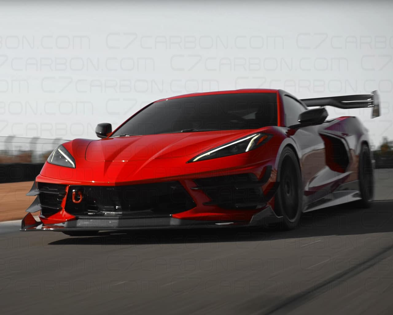 Red Corvette C8 Legacy Edition driving on a racetrack with its side profile visible.