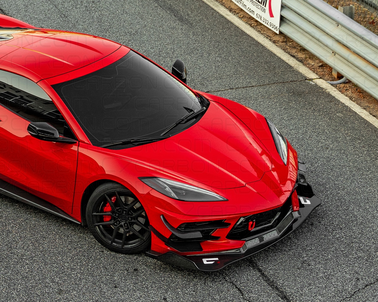 Top view of a red Corvette C8 Legacy Edition with front splitter on a racetrack.