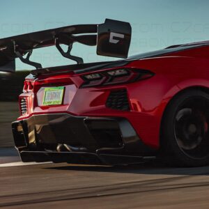 Corvette C8 Legacy Edition with a rear-mounted spoiler, side view while driving on a track.